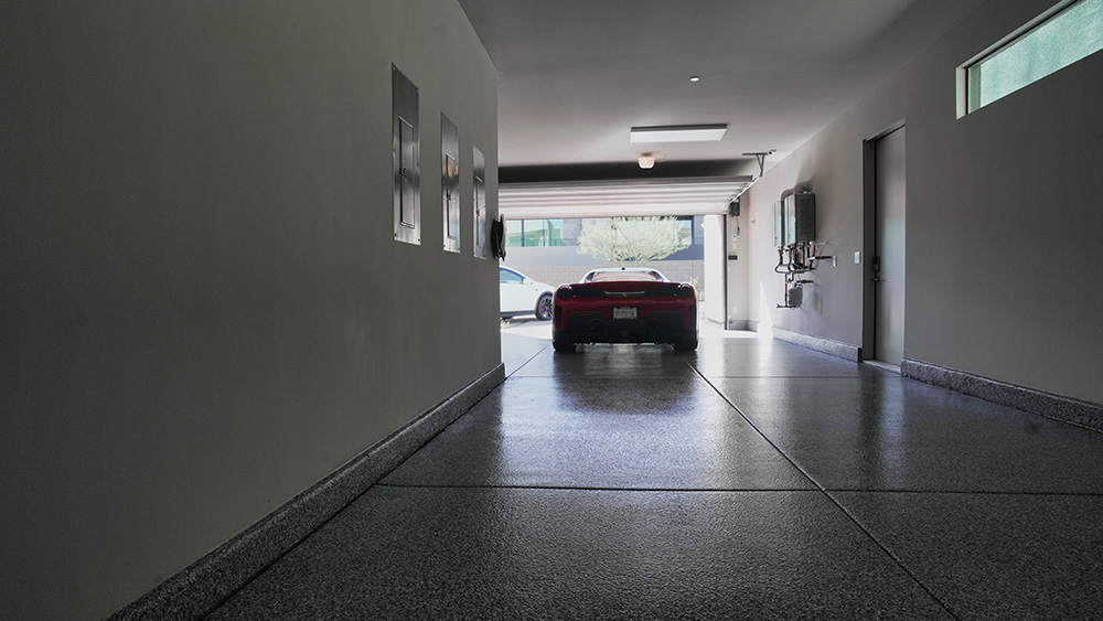 garage with garage floor coating and red car
