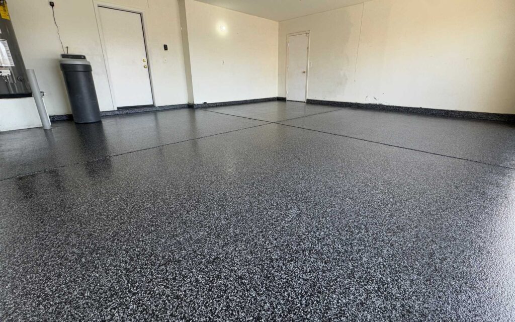 Standard polyurea garage floor coating with Midnight flake finish installed in a residential garage in Las Vegas