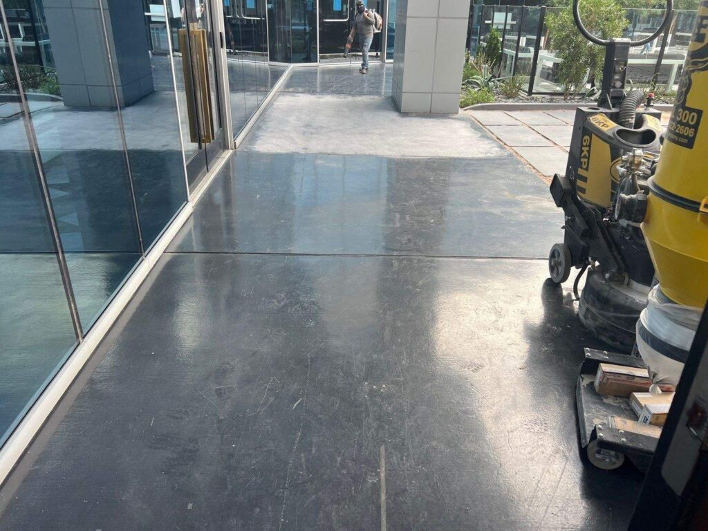 Worn and scratched concrete walkway at a commercial property in Las Vegas prior to quartz coating installation
